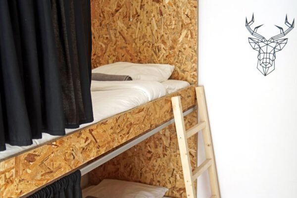 Bunk Bed room with wall art, neatly made beds, clean sheets, curtains and a fresh towel rolled up at Baleal Guest House